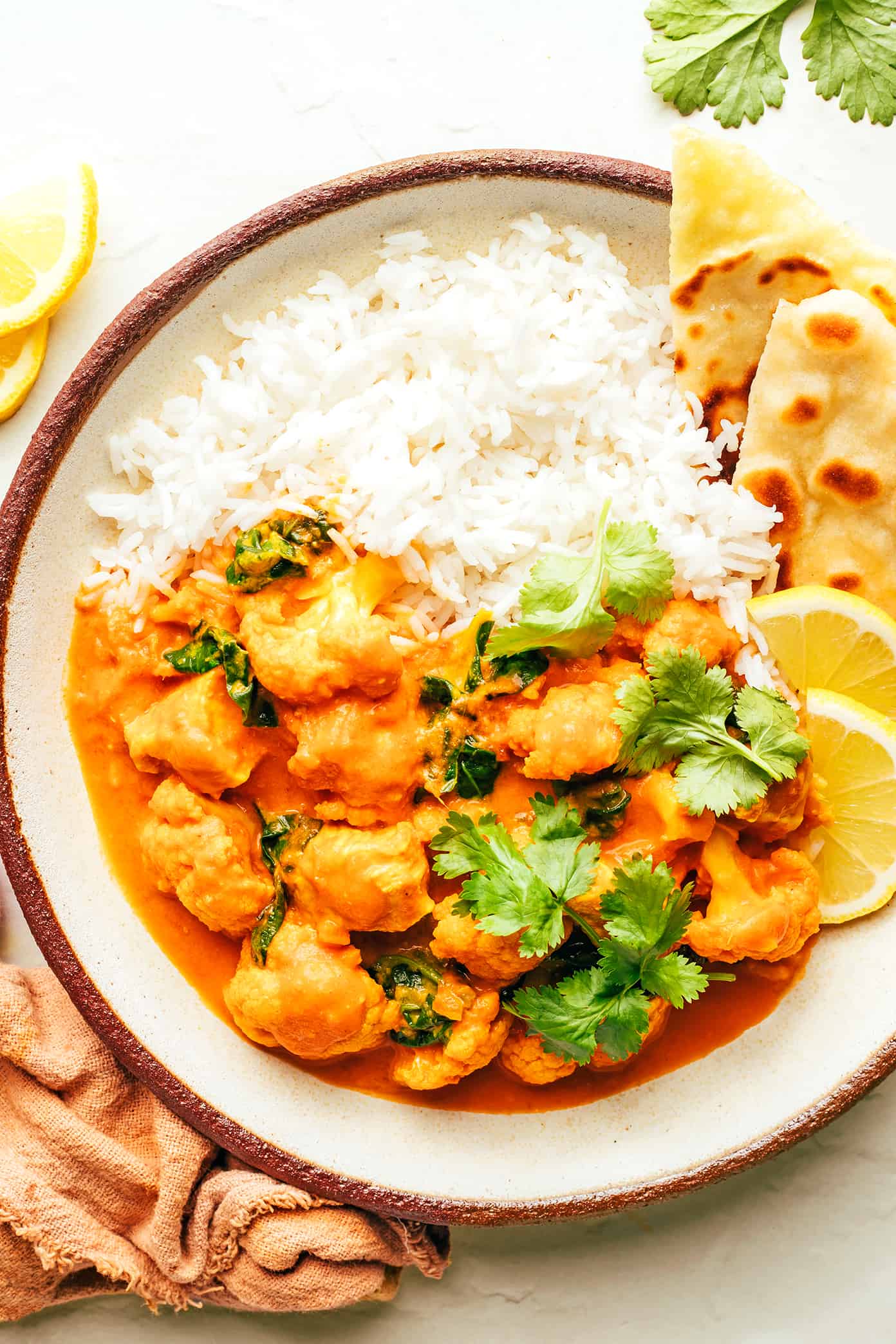 This Indian-inspired butter chicken and cauliflower recipe is easy to make, naturally gluten-free, and simmered with the most delicious curry sauce. Serve with rice or naan and enjoy! | gimmesomeoven.com Butter Chicken and Cauliflower with Rice and Naan in Bowl