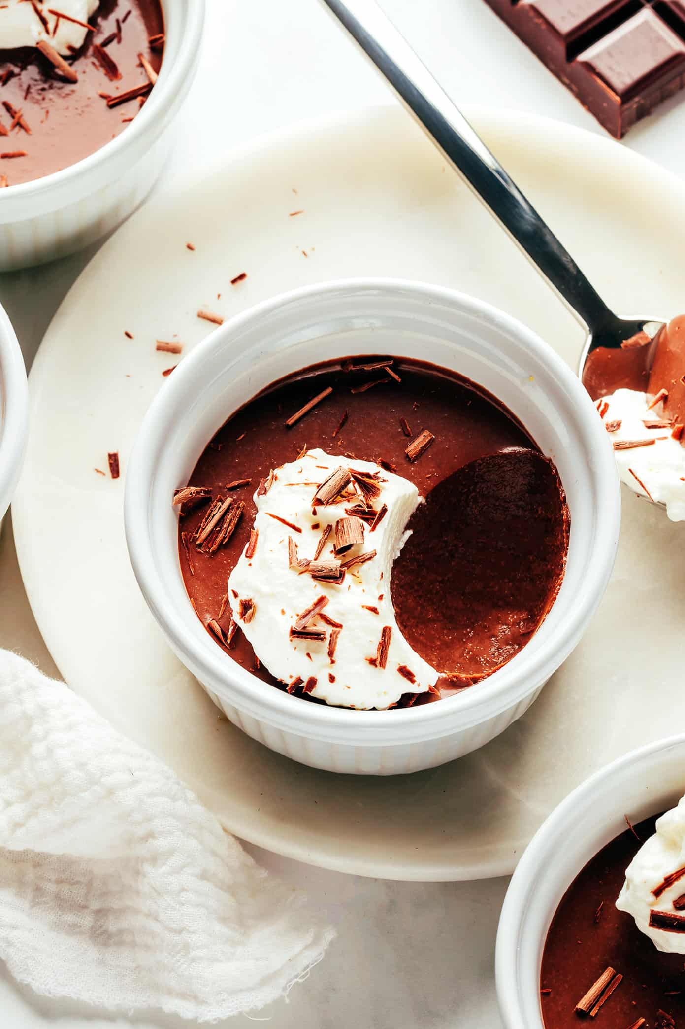 This no-bake chocolate pots de crème recipe comes together with just 20 minutes of active prep time and features a silky-smooth chocolate custard topped with amaretto whipped cream. Naturally gluten-free and the perfect make-ahead dessert for easy entertaining! | gimmesomeoven.com Chocolate Pot de Creme In Ramekin