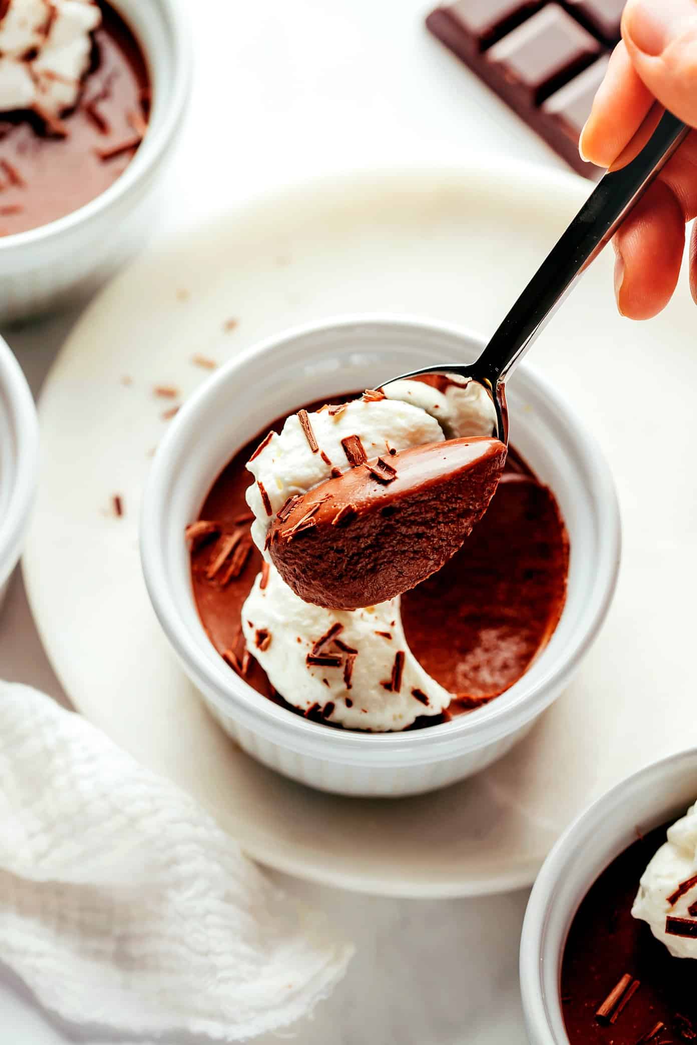 This no-bake chocolate pots de crème recipe comes together with just 20 minutes of active prep time and features a silky-smooth chocolate custard topped with amaretto whipped cream. Naturally gluten-free and the perfect make-ahead dessert for easy entertaining! | gimmesomeoven.com Chocolate Pot de Creme with Spoon