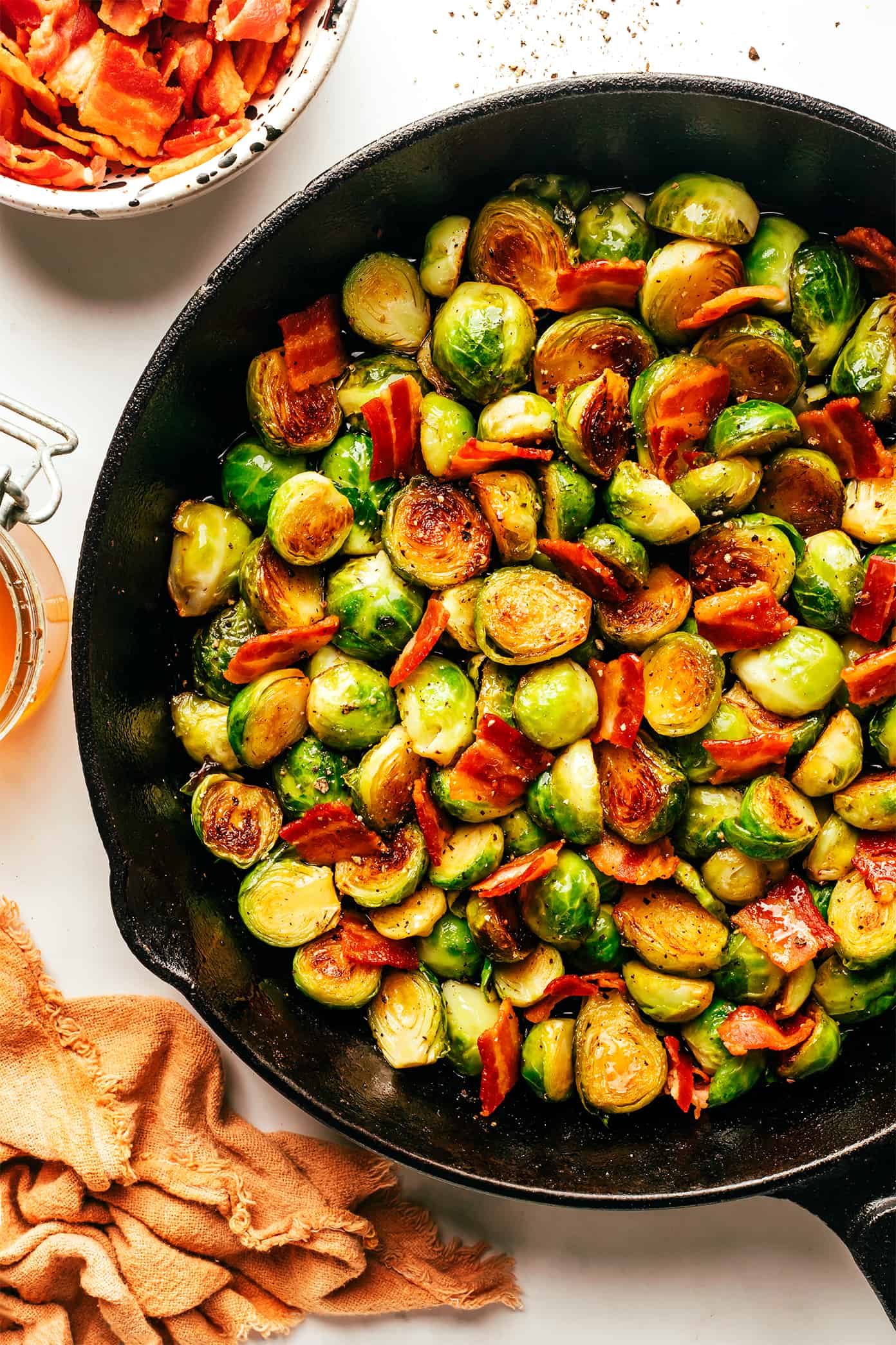 These bacon Brussels sprouts are easy to make and tossed with an irresistible drizzle of hot honey. The perfect side dish for Thanksgiving, dinner parties, or anytime you're just craving some extra-delicious vegetables. | gimmesomeoven.com Bacon Brussels Sprouts with Hot Honey in Skillet