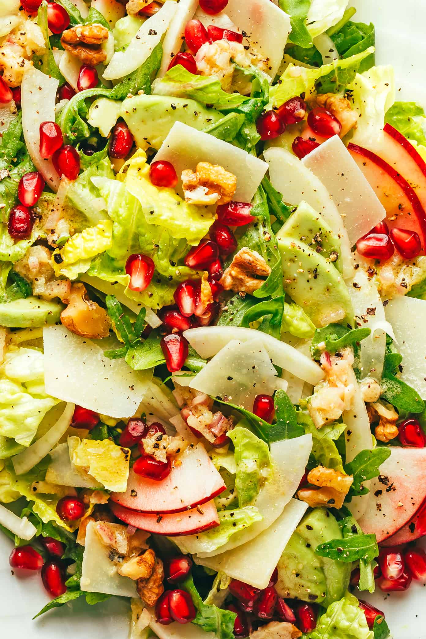 My favorite holiday green salad is tossed with arugula, pomegranate, apple, fennel, toasted walnuts, Parmesan and a simple shallot vinaigrette. Perfect for Thanksgiving, Christmas, or any winter weeknight that you're craving a fresh and delicious salad. | gimmesomeoven.com Christmas Pomegranate Salad Closeup