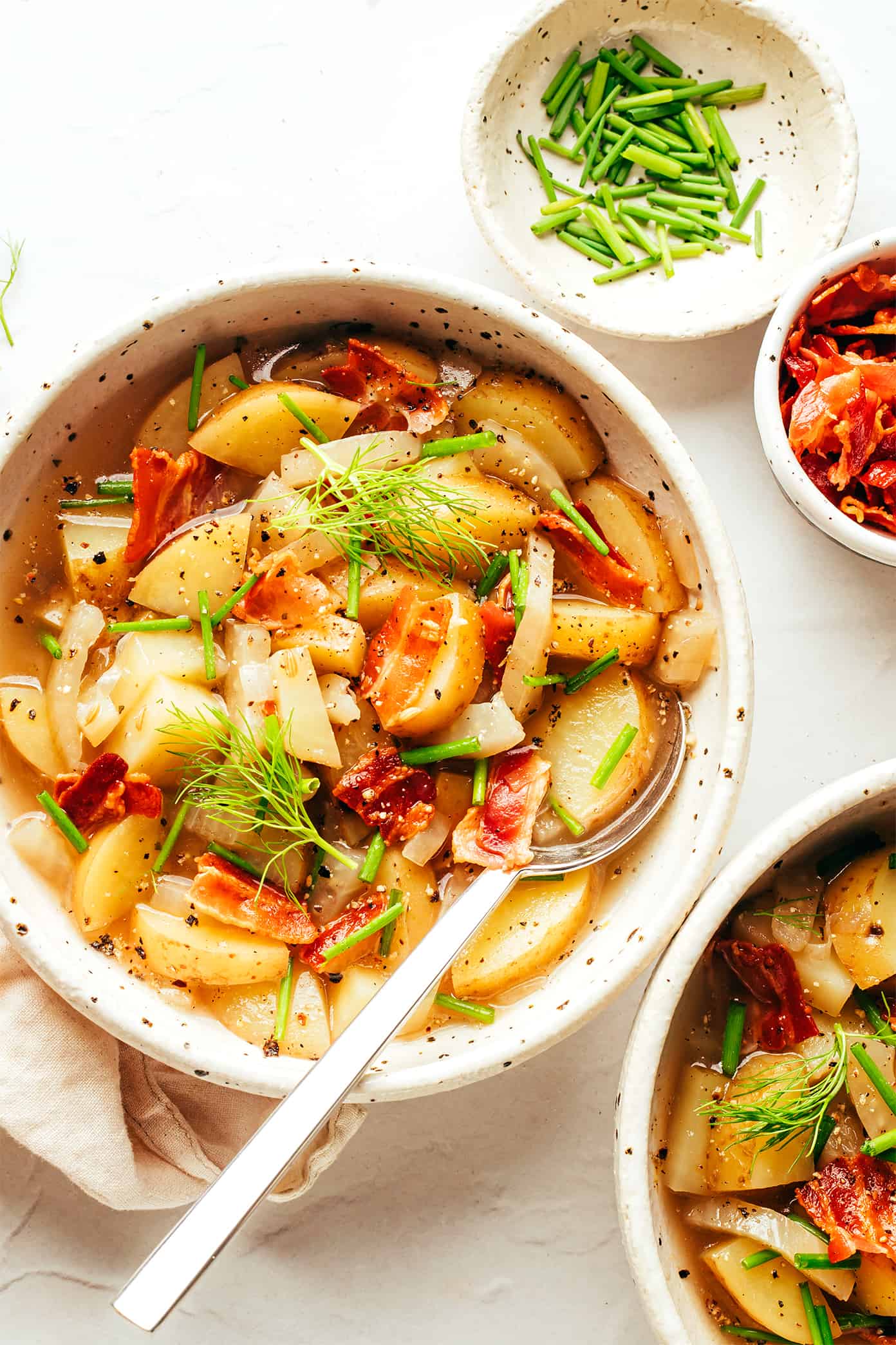 This potato bacon fennel soup recipe is incredibly easy to make and simmered in a garlic-rosemary broth. Easy to make, naturally gluten-free, and always such a cozy and delicious dinner recipe! | gimmesomeoven.com Potato Bacon Fennel Soup in Serving Bowls