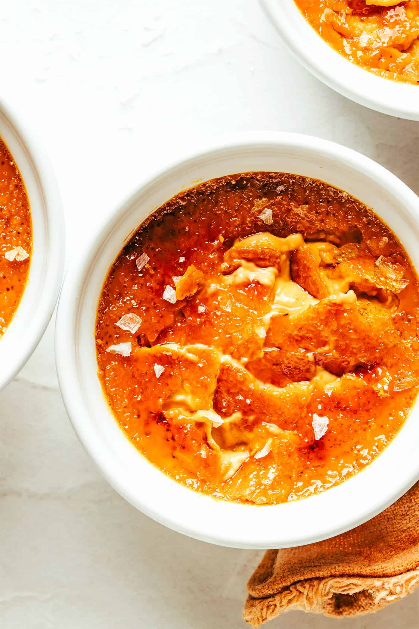 This salted caramel crème brûlée recipe is easy to make with 5 basic ingredients and features a delicious salted caramel custard with a crispy, crackly sugar topping. A delicious dessert that's easy for entertaining and also happens to be gluten-free. | gimmesomeoven.com Salted Caramel Crème Brûlée Closeup in Ramekin