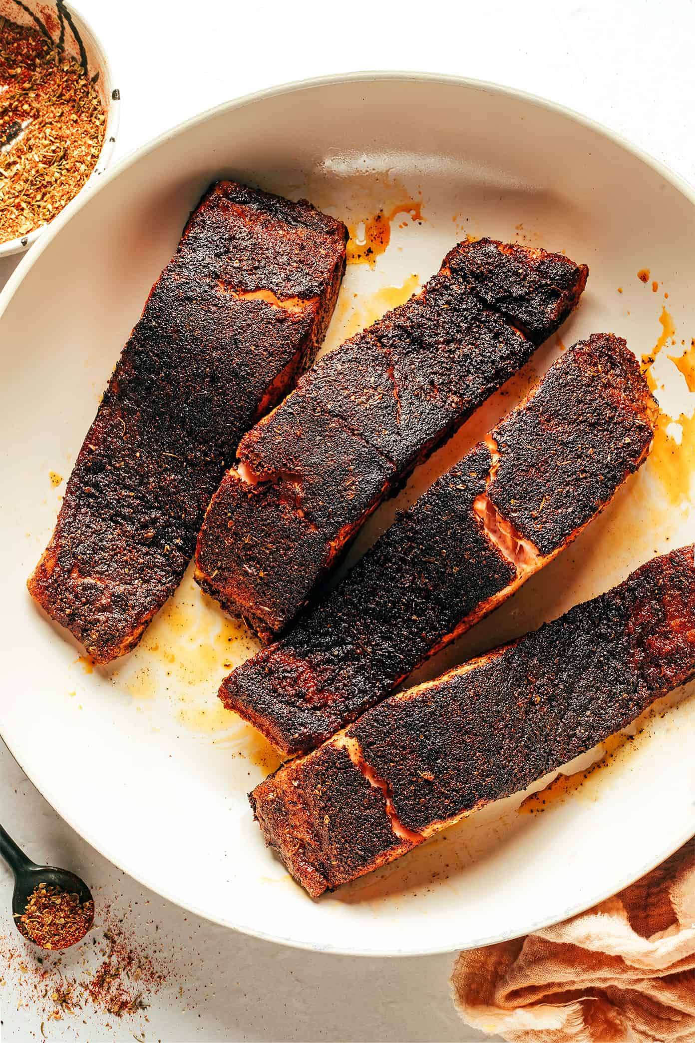 My favorite blackened salmon recipe is easy to make in 20 minutes and features a perfectly-blackened, flavorful, crispy crust. Always such a delicious, quick, and healthy dinner recipe! | gimmesomeoven.com Blackened salmon filets in pan