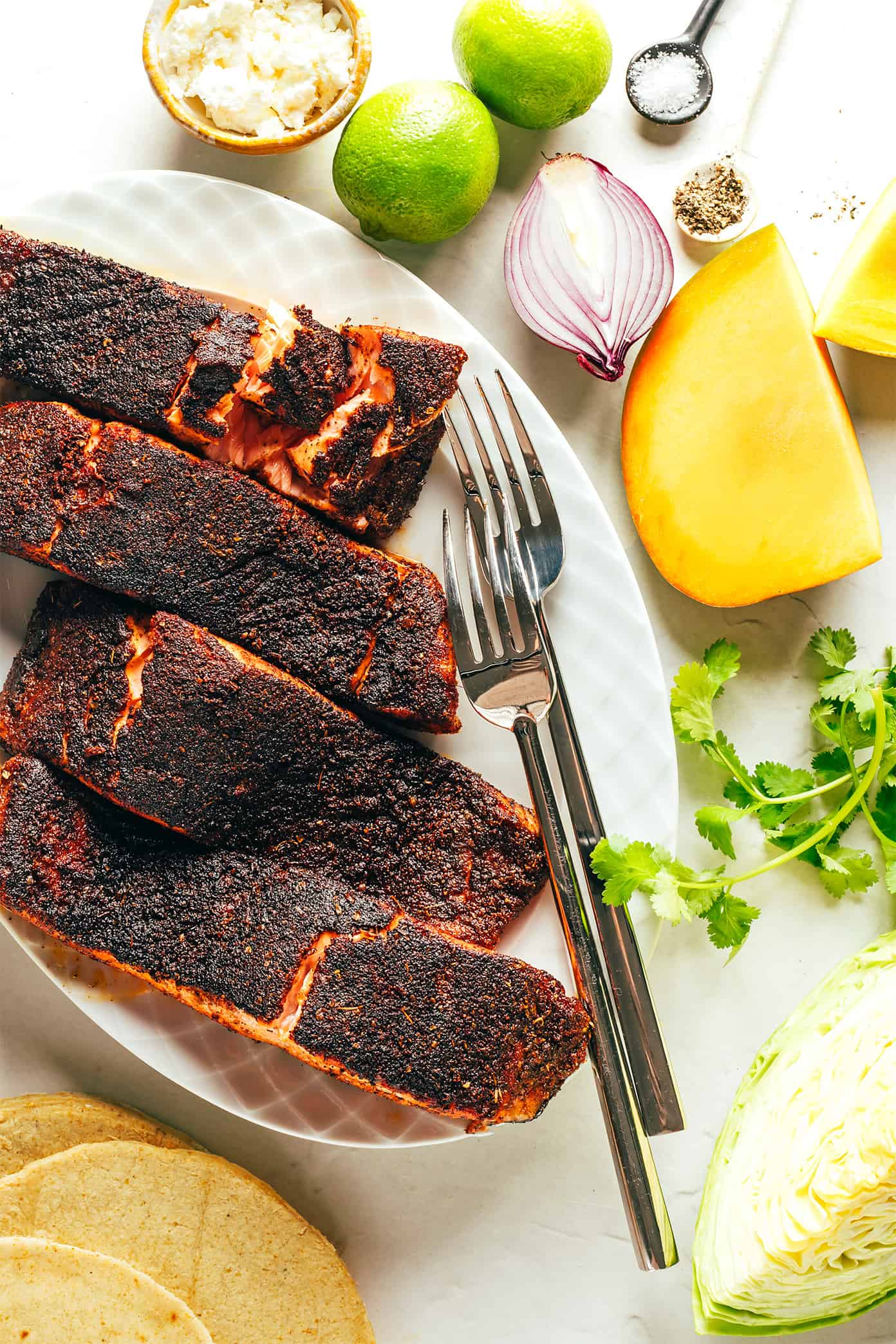 This blackened salmon tacos recipe is layered with a quick mango slaw, corn tortillas, and your choice of zesty toppings. Quick and easy to prepare, naturally gluten-free, and always such a delicious and healthy dinner recipe! | gimmesomeoven.com Blackened Salmon Taco Ingredients