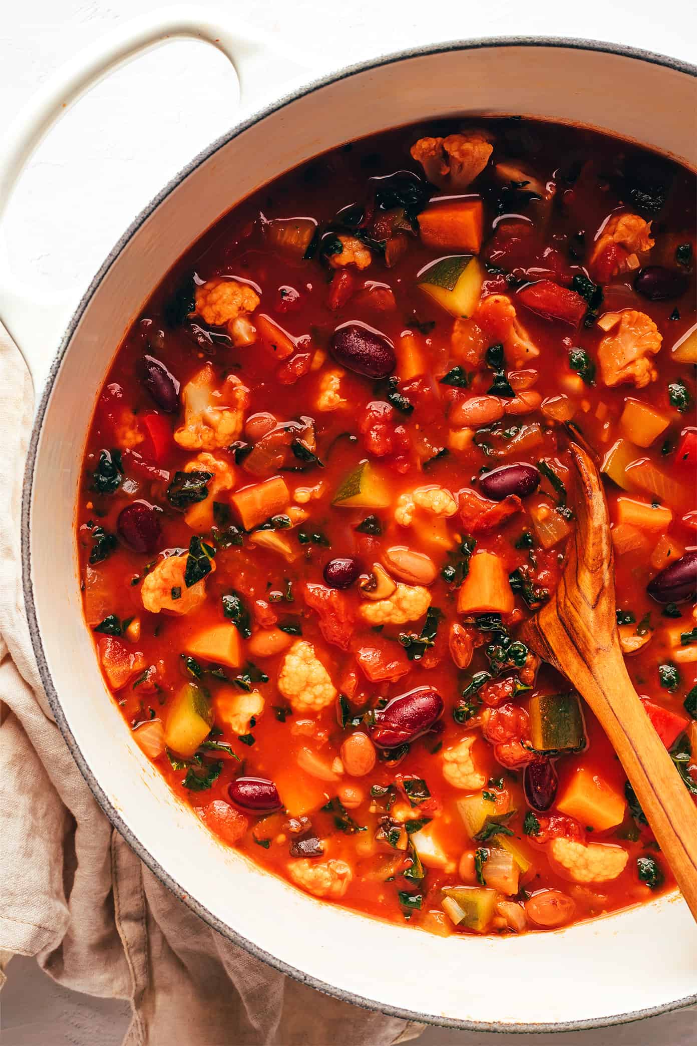 This delicious vegetarian chili recipe is easy to make, full of rich flavor, and loaded up with your choice of beans and veggies (such as sweet potato, bell pepper, zucchini, mushrooms, cauliflower, etc). This soup recipe is naturally gluten-free and vegan, very customizable, and always SO delicious. | gimmesomeoven.com Extra-Veggie Vegetarian Chili in Pot