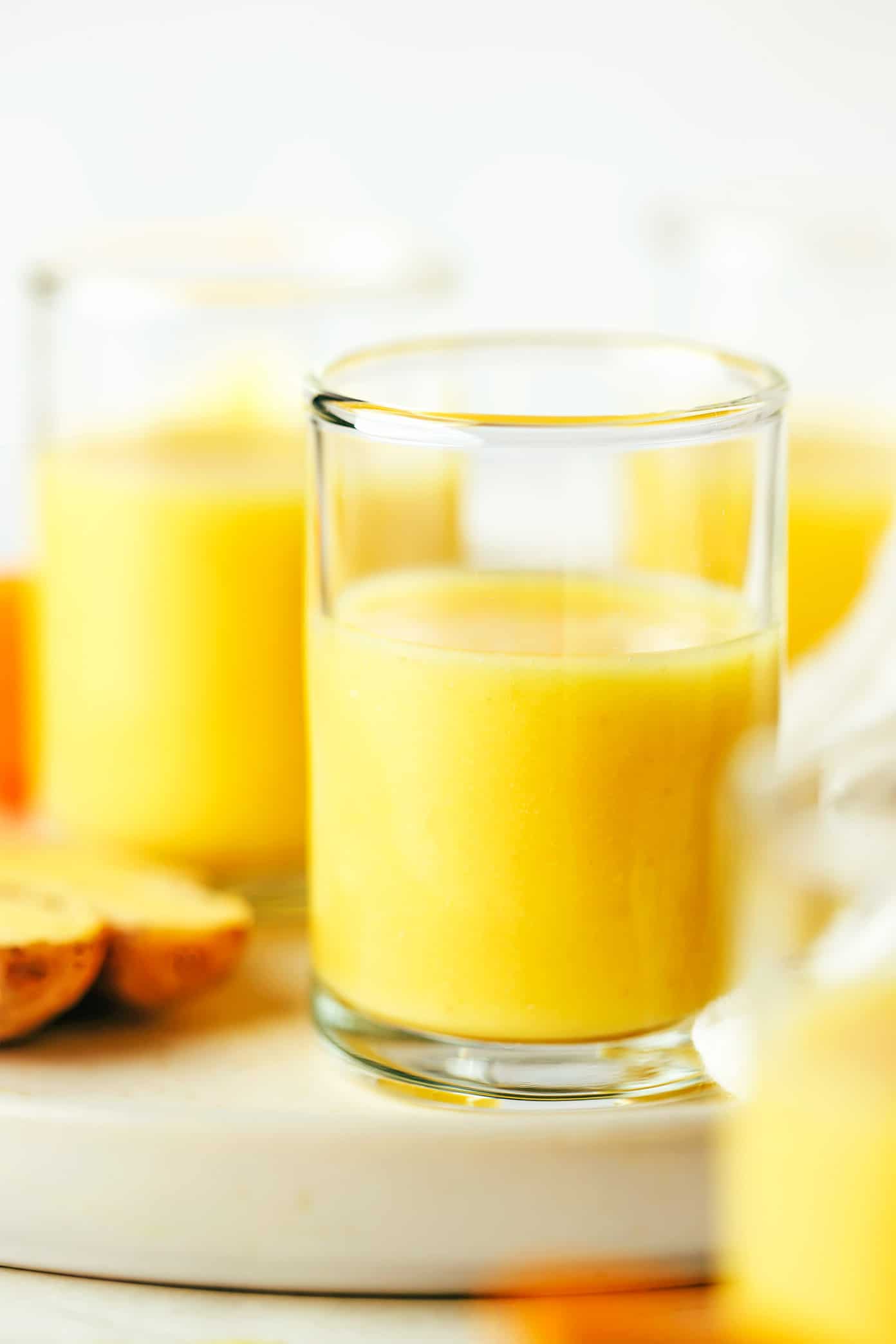 My favorite ginger shot recipe is super easy to make in the blender with 4 ingredients - lemon, orange, coconut water and fresh ginger. Full of healthy anti-inflammatory nutrients, more affordable than the store-bought versions, and easy to customize the flavors to your liking! | gimmesomeoven.com Ginger Shot Closeup in Glass