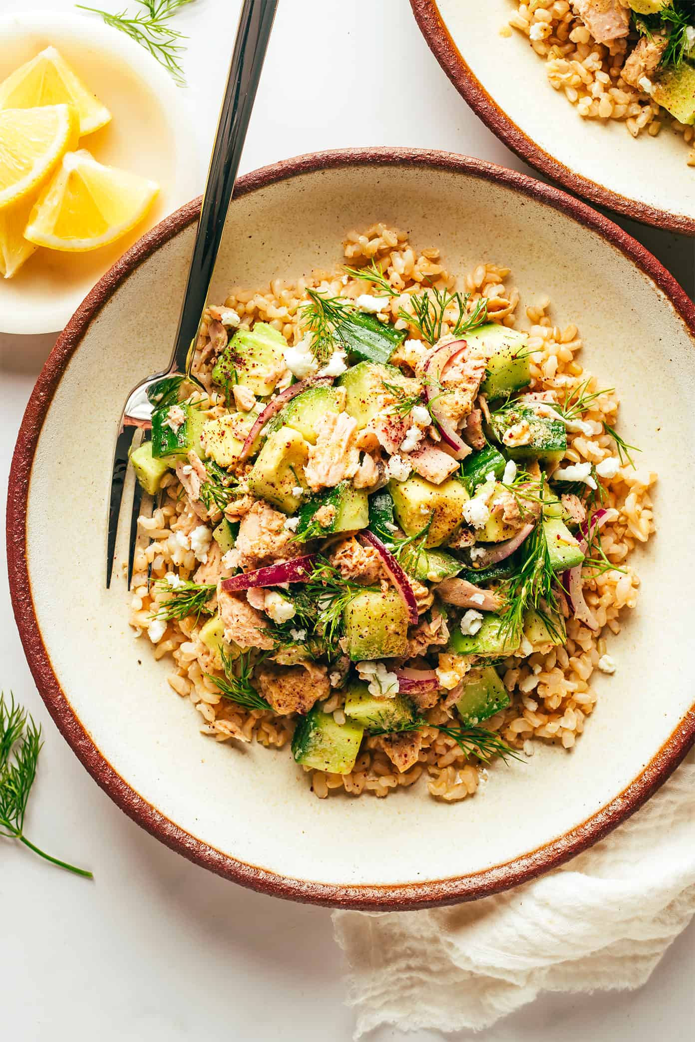 This simple tuna salad is tossed with avocado, cucumber, feta, red onions, herbs and a zippy lemon-sumac dressing and served over brown rice. Easy to make in about 30 minutes, naturally gluten-free, easy to meal prep in advance for lunch or dinner, and always SO delicious. | gimmesomeoven.com Tuna Avocado Brown Rice Bowls with Lemons
