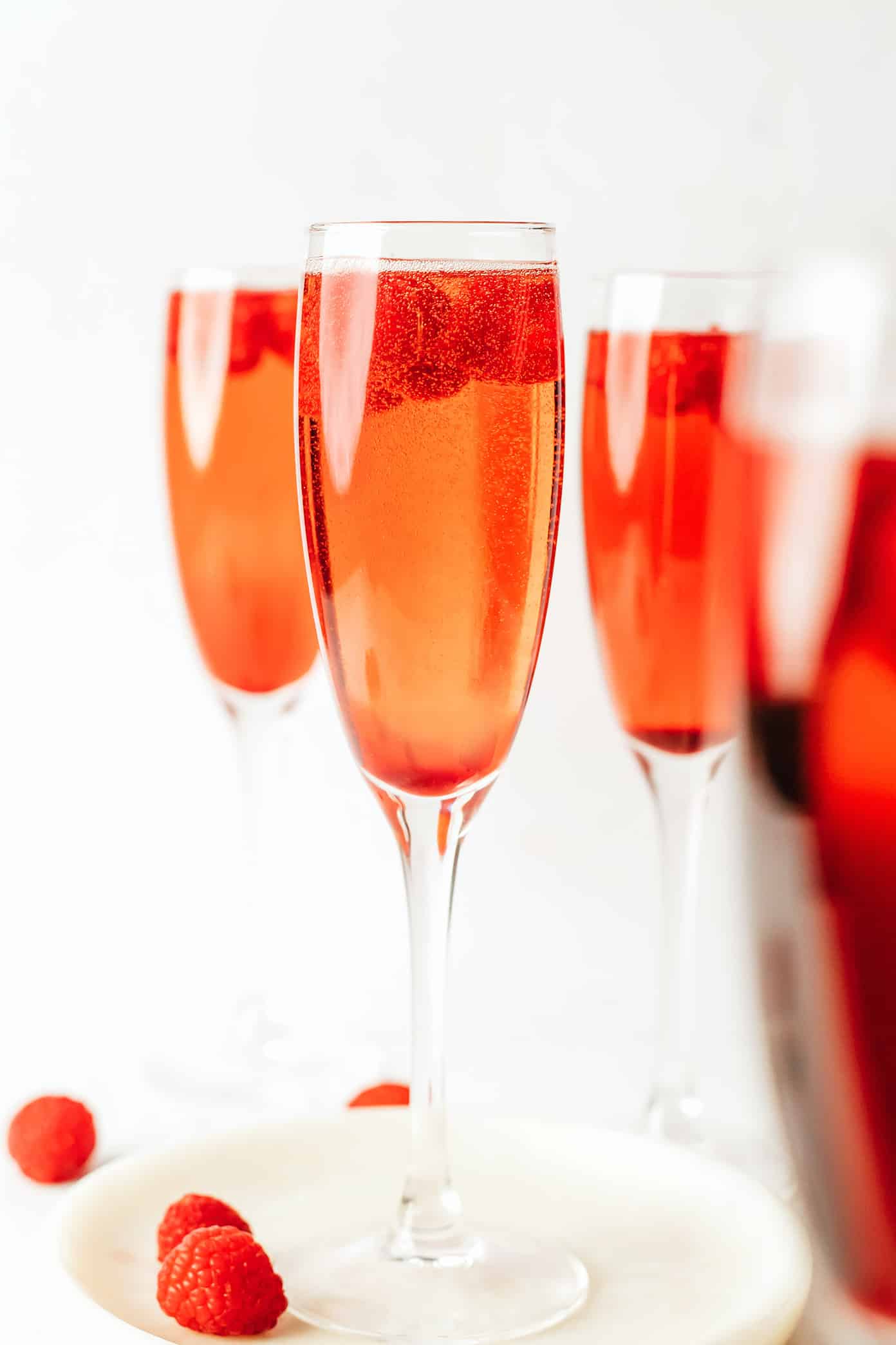 This classic kir royale cocktail recipe is easy to make with dry sparkling wine (such as Champagne, cava or prosecco), crème de cassis (blackcurrant liqueur) and your choice of berries for garnish. It's a vibrant, bubbly, refreshing drink that's perfect for summertime! | gimmesomeoven.com Kir Royale with Raspberries