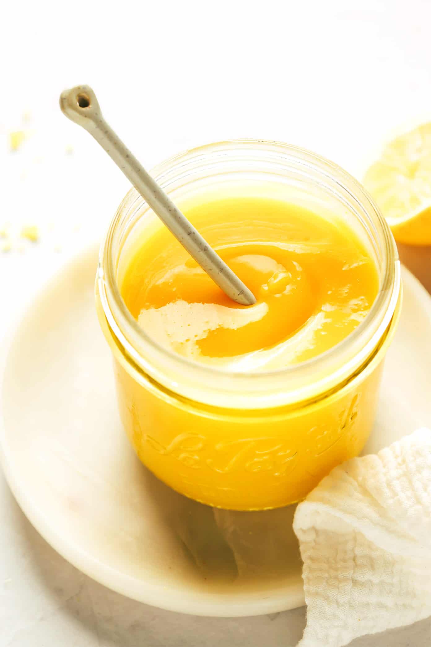 This classic homemade lemon curd recipe is easy to make with 5 ingredients in about 15 minutes. Irresistibly tart, sweet, creamy and delicious, and perfect as a spread or filling for everything from cakes to cookies, crepes, muffins, scones, toast and more. | gimmesomeoven.com Jar of lemon curd with spoon