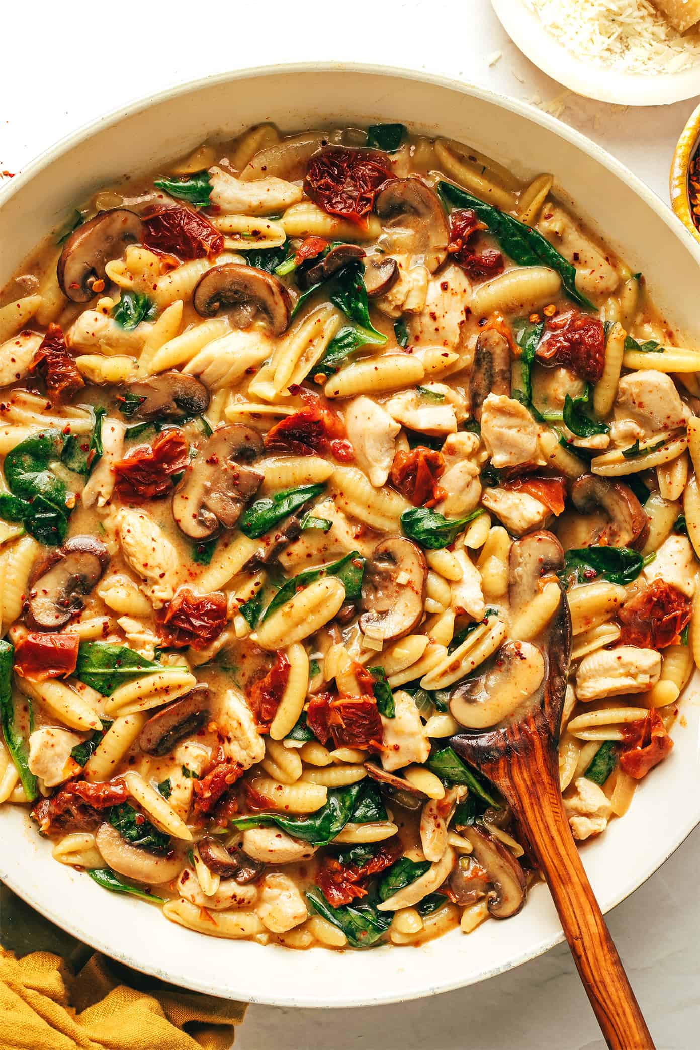 This one pot creamy sun-dried tomato pasta recipe is made with chicken, mushrooms and spinach in a rich garlic basil sauce. Serve topped with lots of Parmesan and enjoy! | gimmesomeoven.com One Pot Creamy Sun-Dried Tomato Pasta in Pan