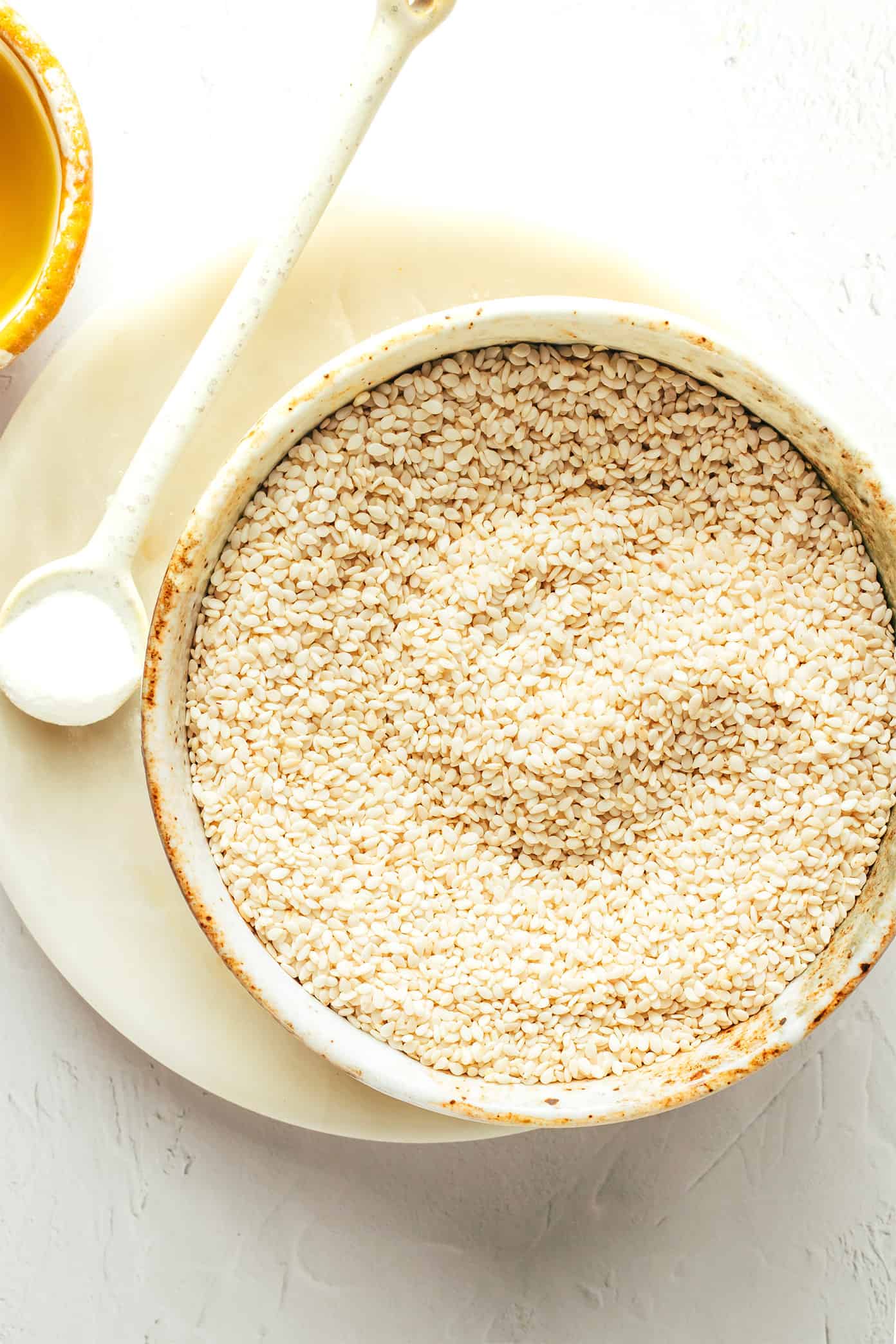 This homemade tahini recipe is easy to make with 3 ingredients and tastes so deliciously nutty and creamy. Use this Middle Eastern condiment to make dips like hummus or baba ganoush, or add it to everything from salad dressings to smoothies, baked goods and more. Naturally gluten-free, vegetarian and vegan. | gimmesomeoven.com Tahini ingredients including sesame seeds, salt and olive oil