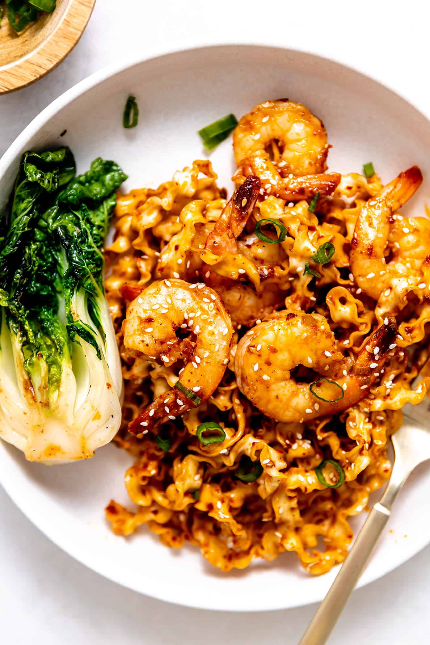 These Chinese-inspired spicy garlic chili oil noodles are quick and easy to make and tossed with the yummiest garlic ginger chili oil. Feel free to toss with shrimp or your choice of protein (such as chicken, beef, pork, tofu) and veggies. Such a delicious, quick and easy dinner recipe! | gimmesomeoven.com Garlic Chili Oil Noodles with Shrimp and Bok Choy on Plate