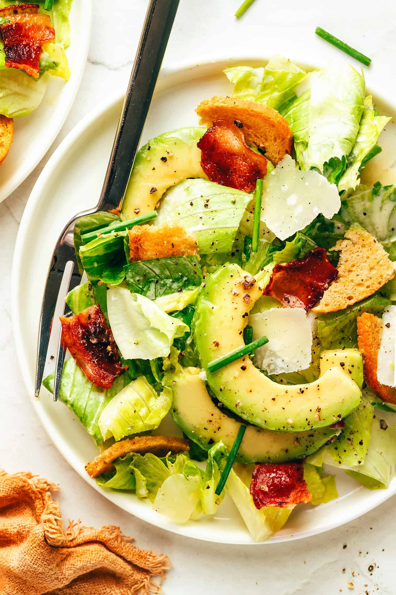 Classic Caesar salad is leveled up with crispy bacon, avocado, rosemary, chives, shaved Parmesan and garlicky croutons. So delicious! | gimmesomeoven.com Bacon Avocado Caesar Salad on Plate with Chives