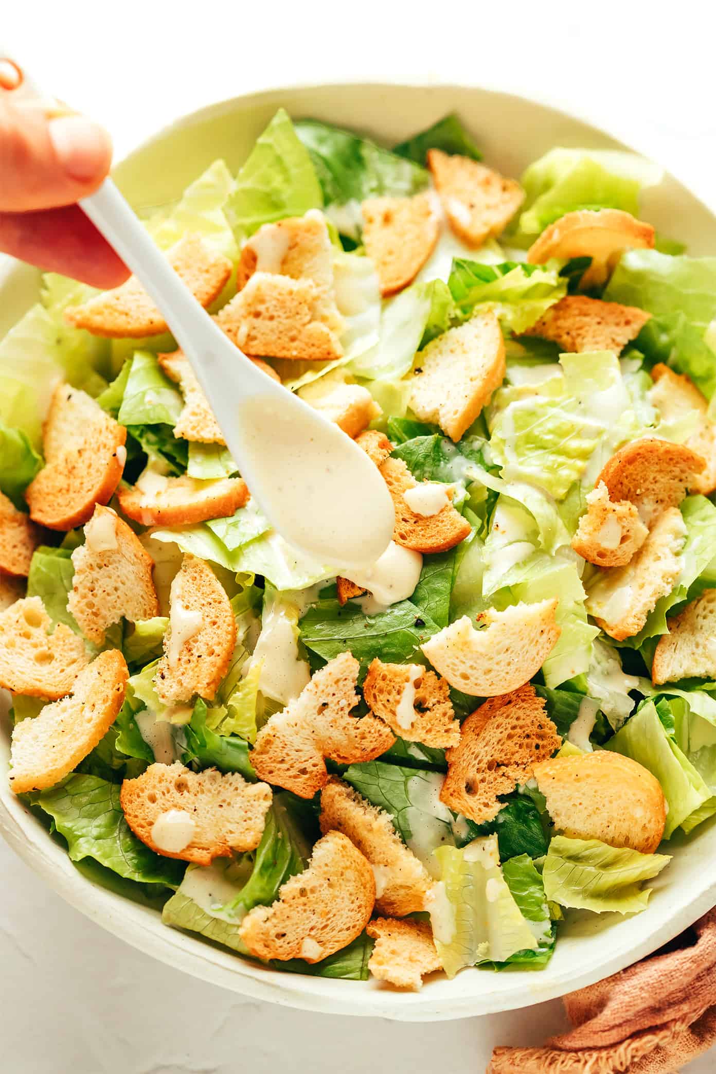 Classic Caesar salad is leveled up with crispy bacon, avocado, rosemary, chives, shaved Parmesan and garlicky croutons. So delicious! | gimmesomeoven.com Adding Caesar dressing to salad