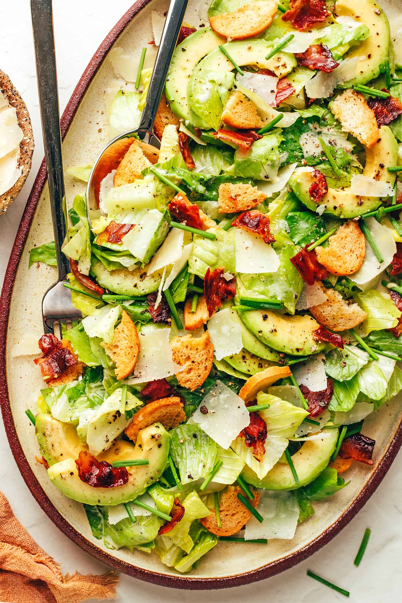 Classic Caesar salad is leveled up with crispy bacon, avocado, rosemary, chives, shaved Parmesan and garlicky croutons. So delicious! | gimmesomeoven.com Homemade Caesar Salad with Bacon and Avocado