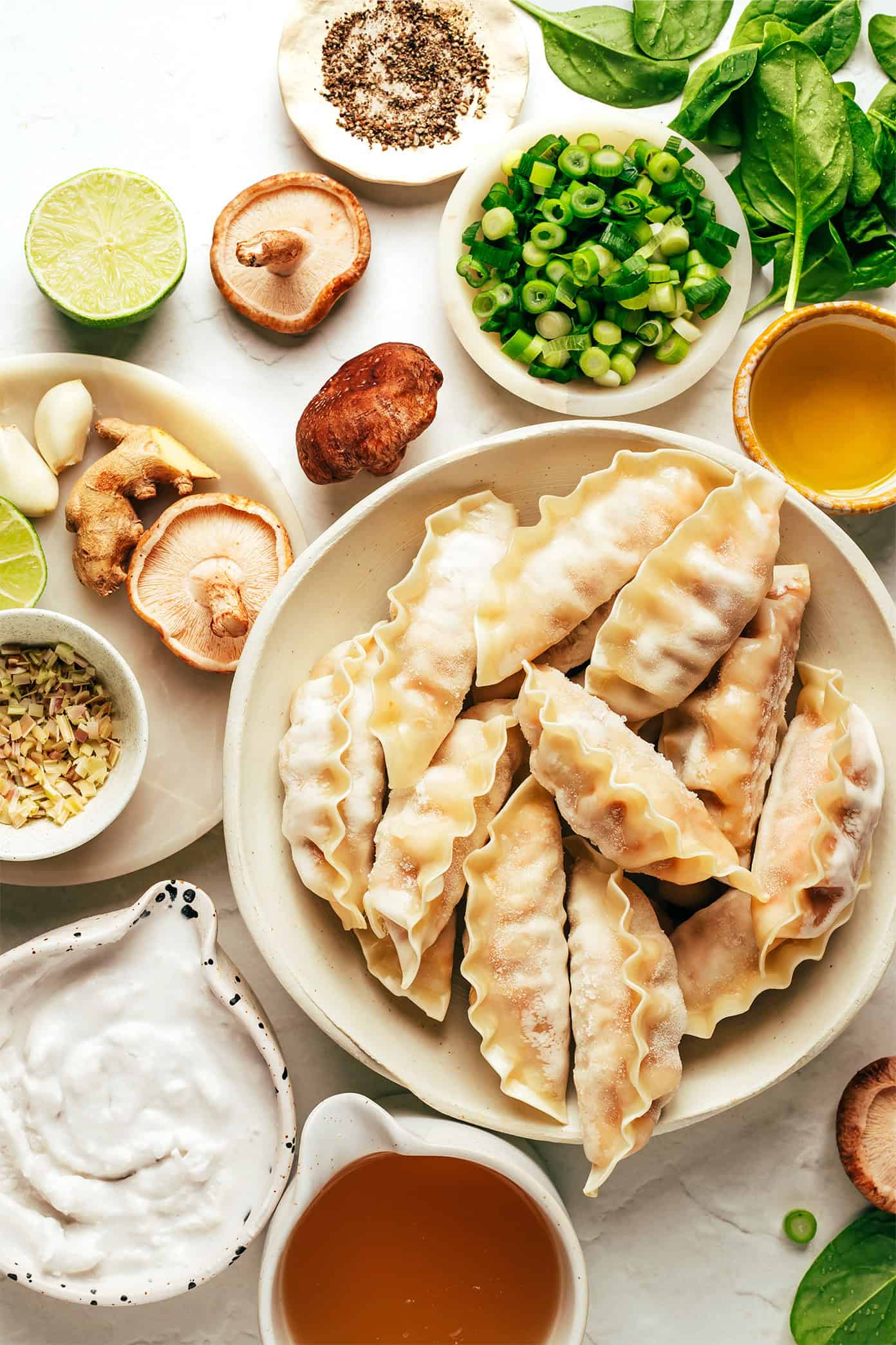 This delicious ginger coconut potsticker soup recipe is quick and easy to make with frozen potstickers, mushrooms and greens, simmered in the most delicious creamy broth with lemongrass and lime. It's a delicious easy dinner recipe that's easy to make vegetarian and gluten-free too. | gimmesomeoven.com Ginger coconut potsticker soup ingredients