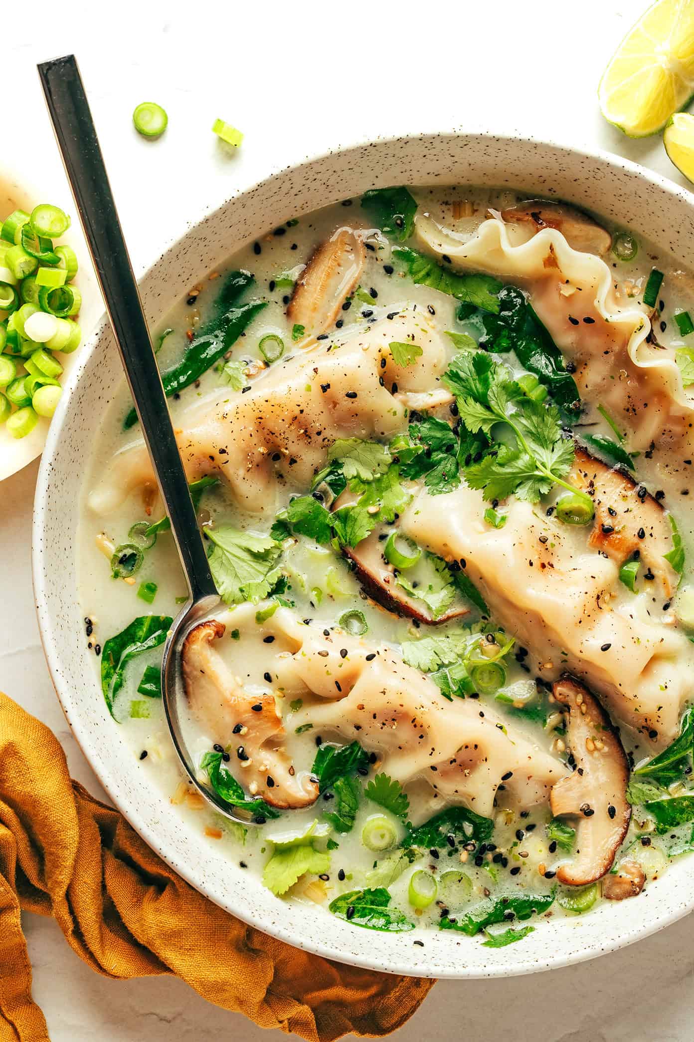 This delicious ginger coconut potsticker soup recipe is quick and easy to make with frozen potstickers, mushrooms and greens, simmered in the most delicious creamy broth with lemongrass and lime. It's a delicious easy dinner recipe that's easy to make vegetarian and gluten-free too. | gimmesomeoven.com Ginger Coconut Potsticker Soup