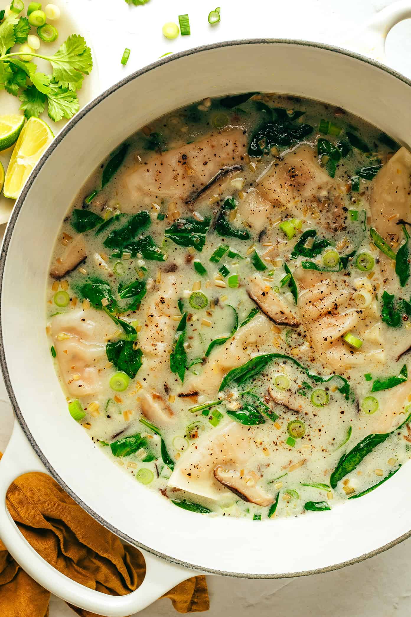 This delicious ginger coconut potsticker soup recipe is quick and easy to make with frozen potstickers, mushrooms and greens, simmered in the most delicious creamy broth with lemongrass and lime. It's a delicious easy dinner recipe that's easy to make vegetarian and gluten-free too. | gimmesomeoven.com Ginger coconut potsticker soup